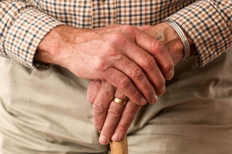 Image of an elderly retired man hold a cane