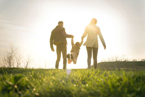 Image of a happy family, husband wife and child walking in a park